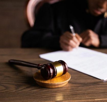 Judge signs document next to gavel